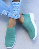 Grüne Slip-On-Sneaker mit weißer Sohle, atmungsaktivem Strickmaterial, ideal für Freizeit und Sport. Perfekt kombinierbar mit Jeans.