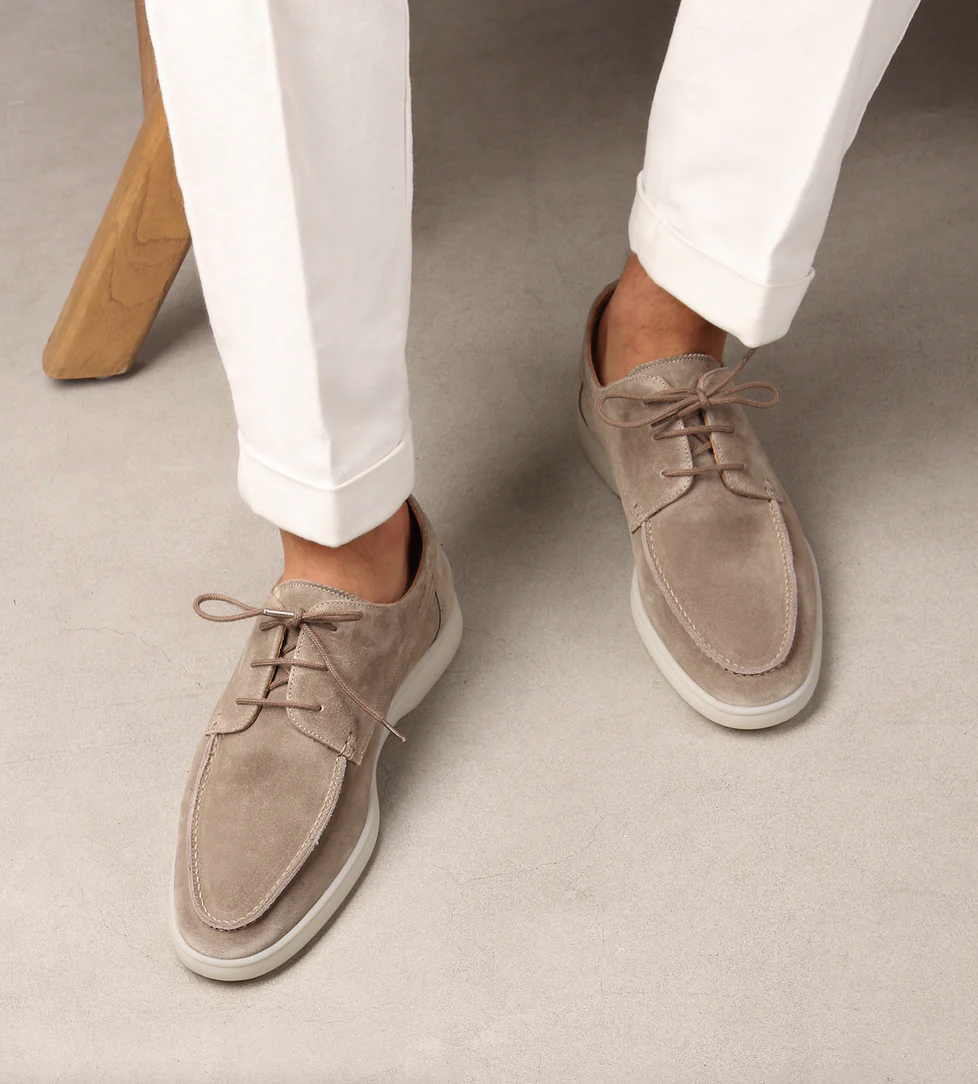 Beige Wildleder-Herrenschuhe, Schnürschuhe, kombiniert mit weißen Hosen, elegantes Design.
