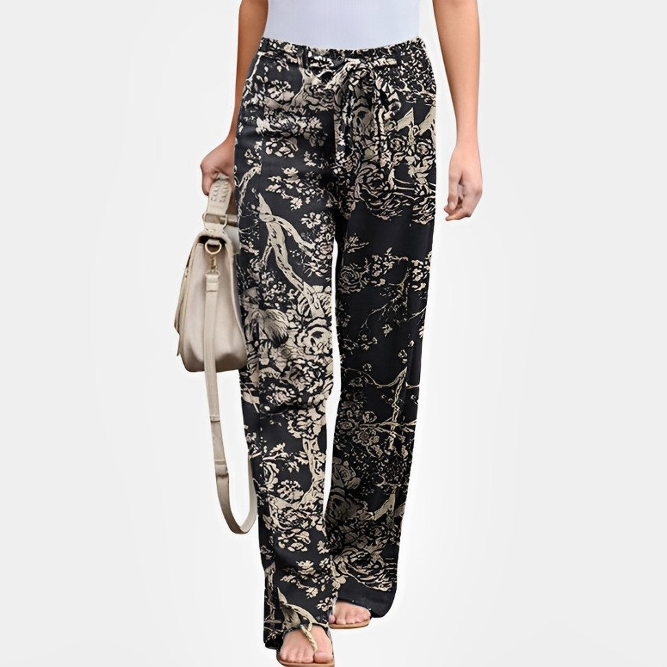 Damenhose mit floralem Print, schwarz-beige, locker geschnitten, ideal für Sommermode. Perfekt kombinierbar mit weißen Oberteilen und Sandalen.