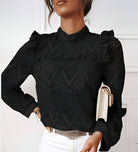 Elegante schwarze Spitzenbluse mit Rüschenärmeln, kombiniert mit weißer Hose. Perfekt für stilvolle Damenmode und trendige Outfits.