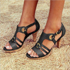 Schwarze Sandaletten mit Blockabsatz und goldenen Schnallen auf geflochtenem Untergrund. Modische Damenschuhe, ideal für Sommer und Freizeit.