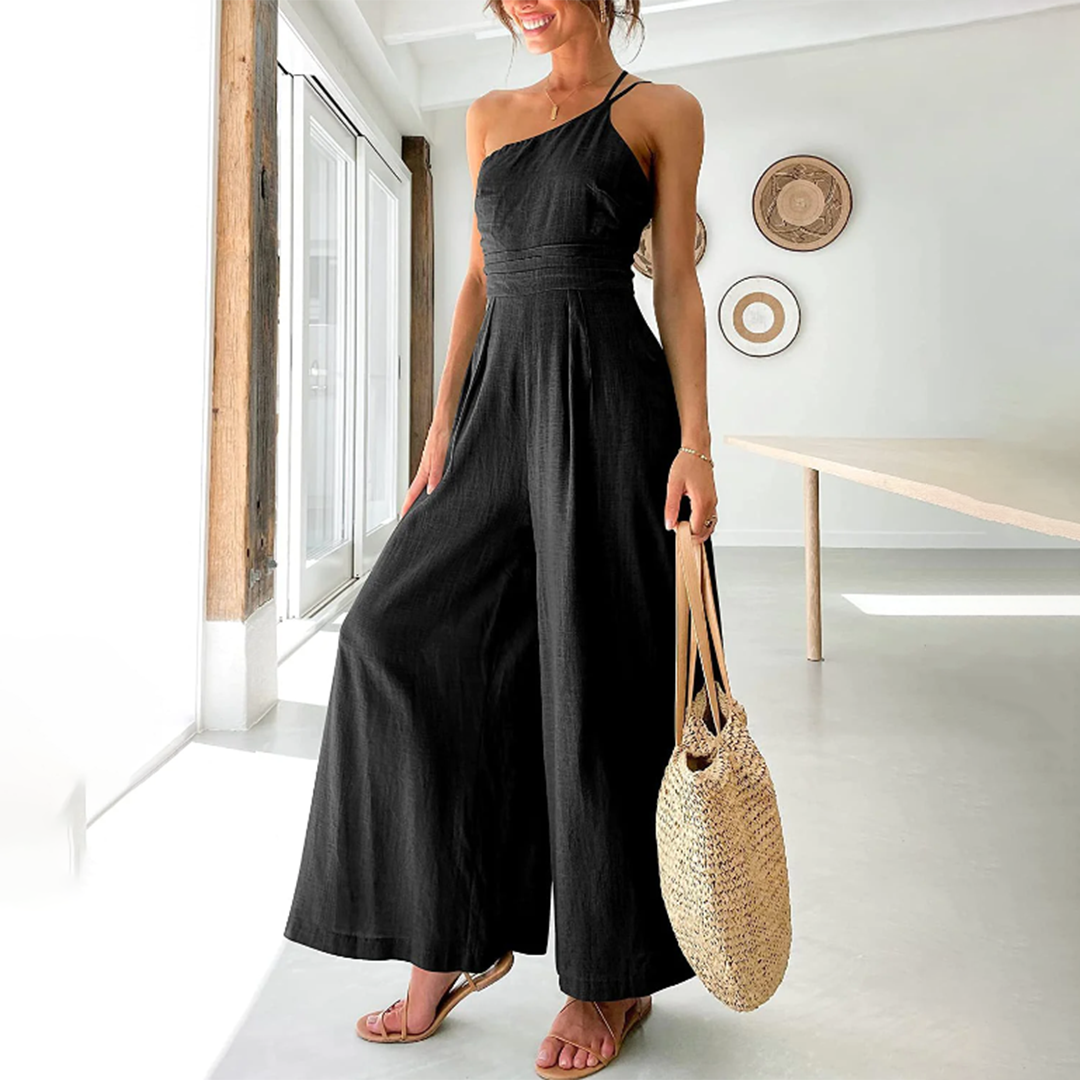 Frau in schwarzem Jumpsuit mit Strohtasche, Sommermode, elegantes Design, Innenraum.