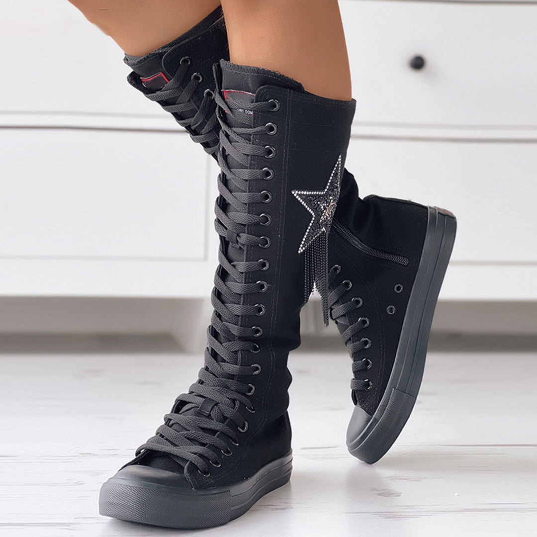 Schwarze, kniehohe Schnürstiefel mit Sternapplikation, ideal für modische Streetwear. Perfekt für trendige Outfits und urbanen Stil.