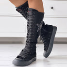 Schwarze, kniehohe Schnürstiefel mit Sternapplikation, ideal für modische Streetwear. Perfekt für trendige Outfits und urbanen Stil.