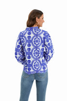 Damenbluse mit blauem, floralem Muster auf weißem Hintergrund, langärmlig, ideal für modische Freizeitoutfits. Hochwertige Baumwolle.