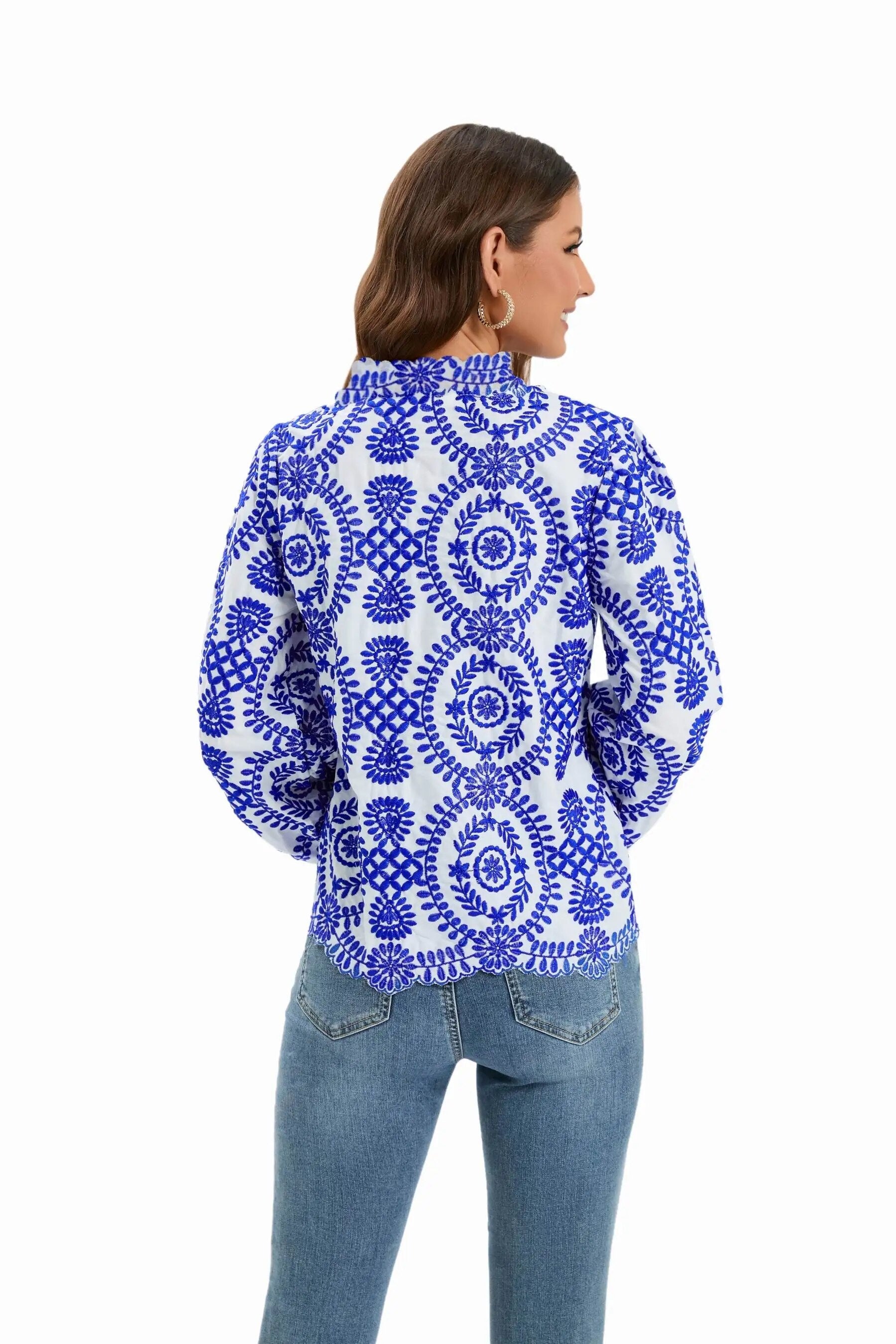 Damenbluse mit blauem, floralem Muster auf weißem Hintergrund, langärmlig, ideal für modische Freizeitoutfits. Hochwertige Baumwolle.