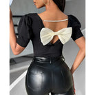 Schwarze Damenbluse mit Puffärmeln, rundem Ausschnitt und weißer Schleife. Elegante, modische Oberbekleidung für stilvolle Anlässe.