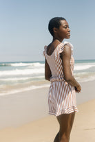 Frau am Strand in gestreiftem Badeanzug mit integriertem BH, Sommermode, Strandkleidung.