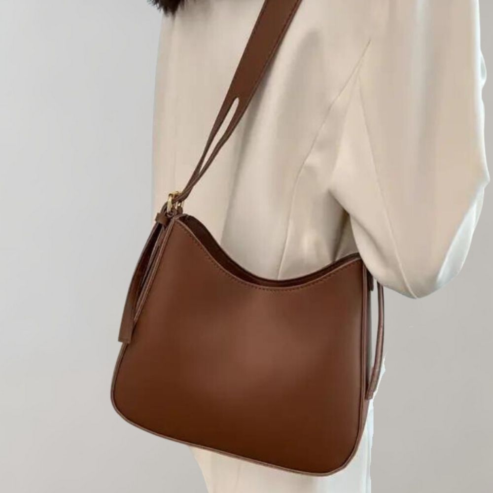 Braune Lederhandtasche mit Schulterriemen, elegantes Design, ideal für Damenmode, stilvolles Accessoire für Alltag und besondere Anlässe.