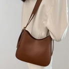 Braune Lederhandtasche mit Schulterriemen, elegantes Design, ideal für Damenmode, stilvolles Accessoire für Alltag und besondere Anlässe.