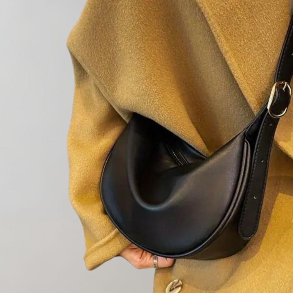 Elegante schwarze Lederhandtasche mit abgerundeter Form, ideal für Damenmode. Perfekt für stilvolle Outfits und modische Accessoires.
