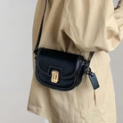 Schwarze Leder-Umhängetasche mit goldener Schnalle, elegantes Design, ideal für Damenmode, vielseitig und stilvoll für den Alltag.