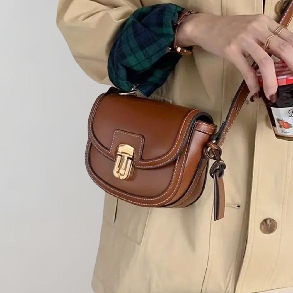 Braune Ledertasche mit goldener Schnalle, elegant und stilvoll. Perfekt für Damenmode, Accessoires, Handtaschen, Vintage-Look.