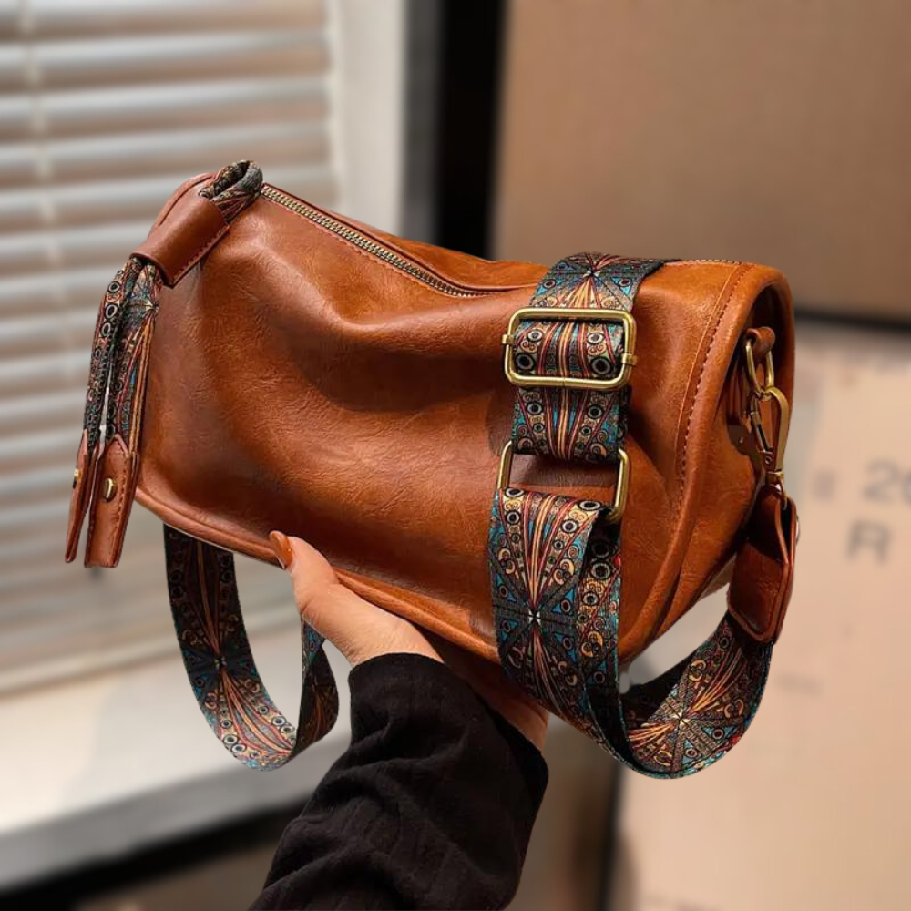 Braune Ledertasche mit verstellbarem, gemustertem Schultergurt. Stilvolle Handtasche, ideal für Damenmode und Accessoires. Hochwertiges Design.