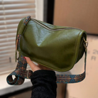 Grüne Lederhandtasche mit verstellbarem, gemustertem Schultergurt. Stilvoll und praktisch, ideal für den täglichen Gebrauch.