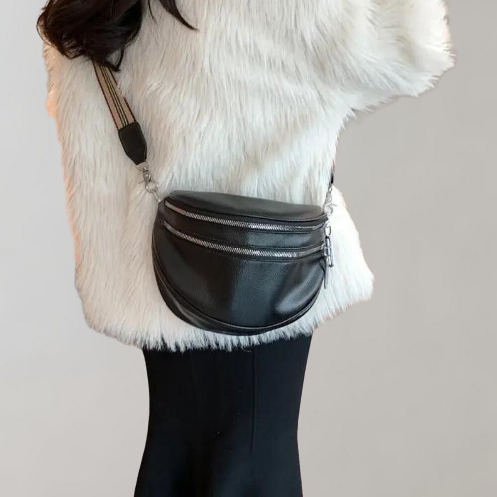 Schwarze Leder-Gürteltasche mit silbernen Reißverschlüssen, ideal für stilvolle Damenmode. Perfekt für Freizeit und Reisen.