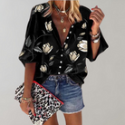Frau in schwarzer Blumenbluse, Jeansshorts, Leoparden-Clutch; modisches Outfit, Freizeitlook.