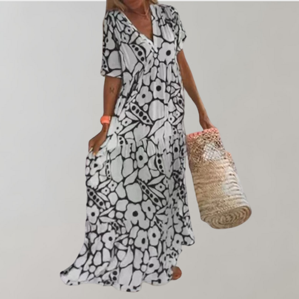 Frau in langem, schwarz-weißem Blumenkleid mit Strohtasche, Sommermode, Freizeitkleidung.