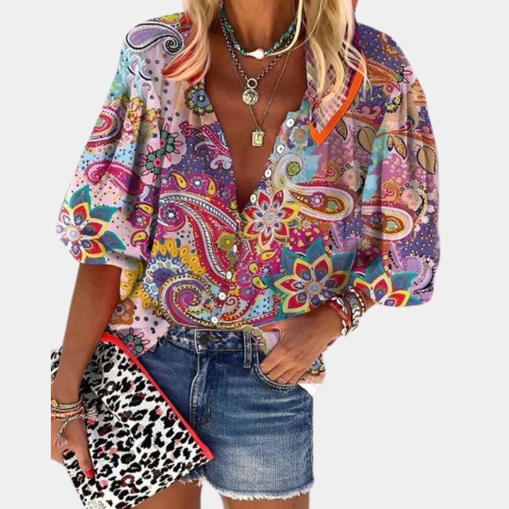 Bunte Damenbluse mit Paisley-Muster, V-Ausschnitt und Puffärmeln, kombiniert mit Jeansrock.