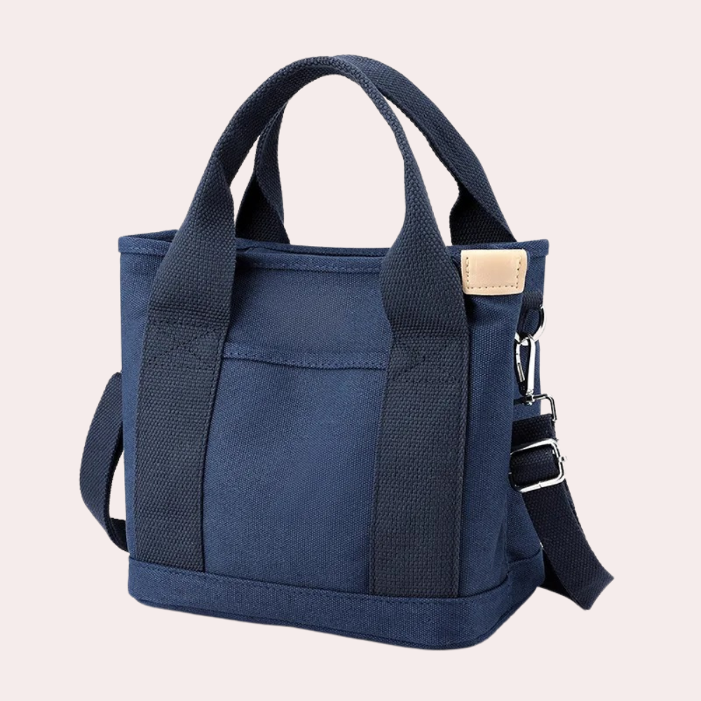 Dunkelblaue Canvas-Tasche mit verstellbarem Schultergurt, robustem Design und Lederakzent. Perfekt für Alltag und Reisen.