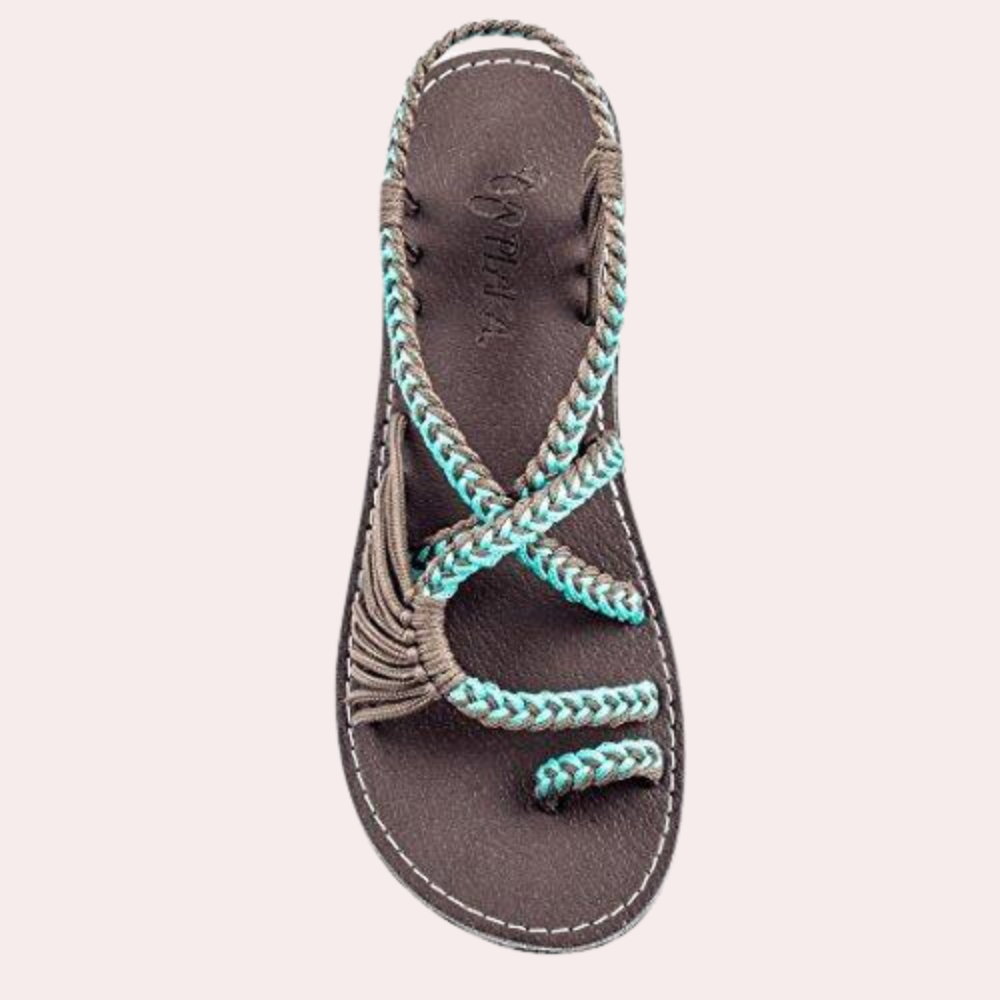 Braune Sandale mit blauen Akzenten, geflochtenem Riemen und bequemer Sohle. Perfekt für Sommermode und Strandoutfits.