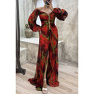 Frau in rotem, schulterfreiem Abendkleid mit Blumenmuster und hohem Schlitz, elegantes Design.