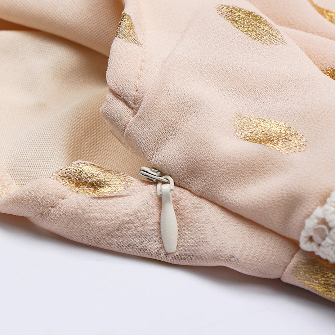 Beiger Stoff mit goldenen Punkten und Reißverschluss. Hochwertiges Textildesign, ideal für Mode und Bekleidung. Elegantes, modernes Muster.