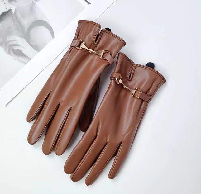 Braune Lederhandschuhe mit eleganten Schnallen auf weißem Hintergrund. Hochwertige Damenhandschuhe, stilvoll und perfekt für den Winter.