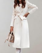 Eleganter Damen-Wollmantel in Cremeweiß mit Gürtel, ideal für Herbst und Winter. Stilvoller Look, perfekt kombiniert mit beiger Handtasche.
