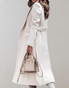 Eleganter weißer Damenmantel aus Wolle, kombiniert mit einer stilvollen, beigen Handtasche. Perfekt für modische Herbst- und Winteroutfits.