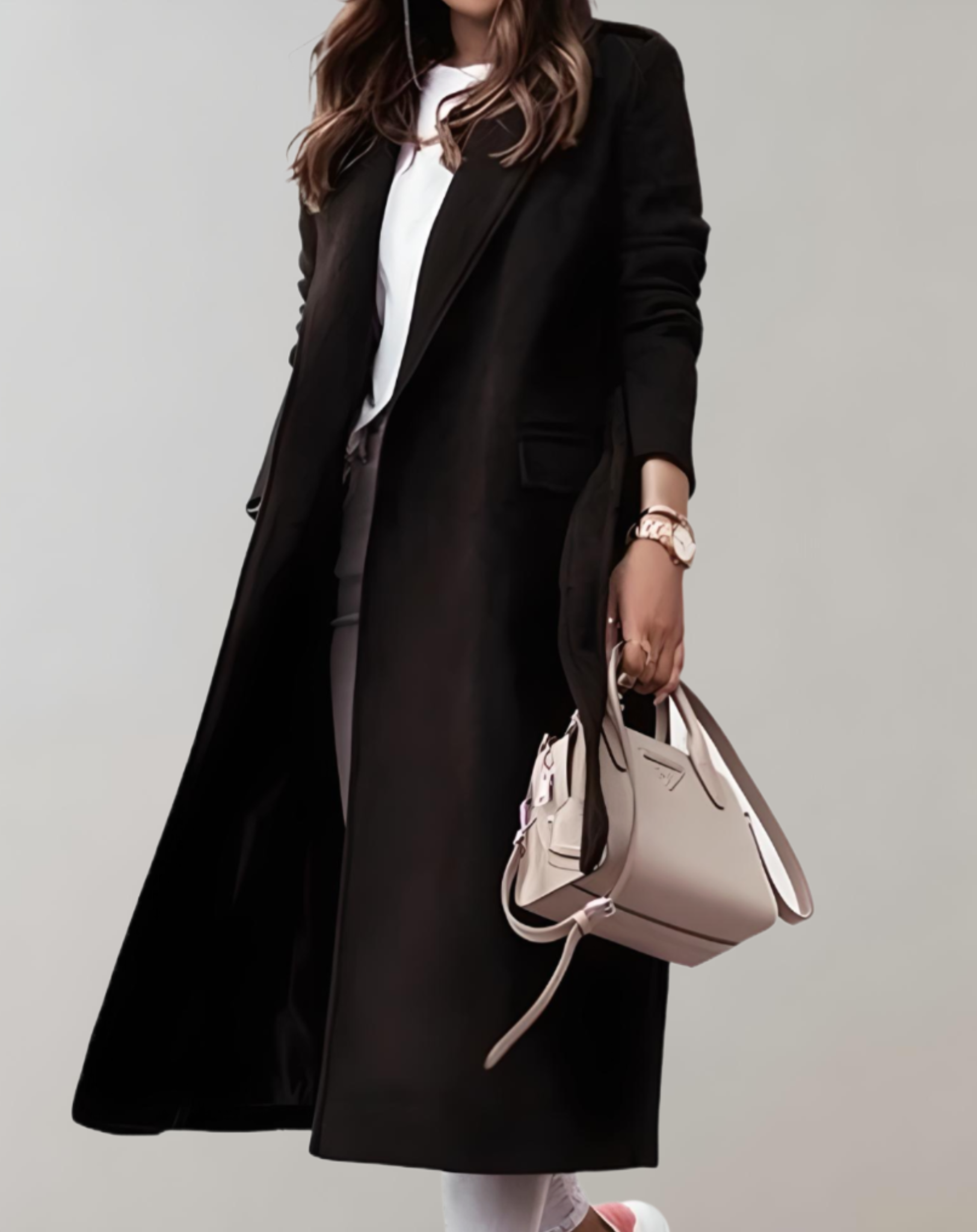 Eleganter schwarzer Mantel für Damen, kombiniert mit weißem Oberteil und beiger Handtasche. Perfekt für stilvolle Herbst- und Wintermode.