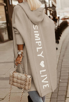 Damen Strickjacke mit Kapuze, beige, Aufschrift "SIMPLY LIVE", lässiger Stil, ideal für Herbstmode. Perfekt für trendige Streetwear-Looks.