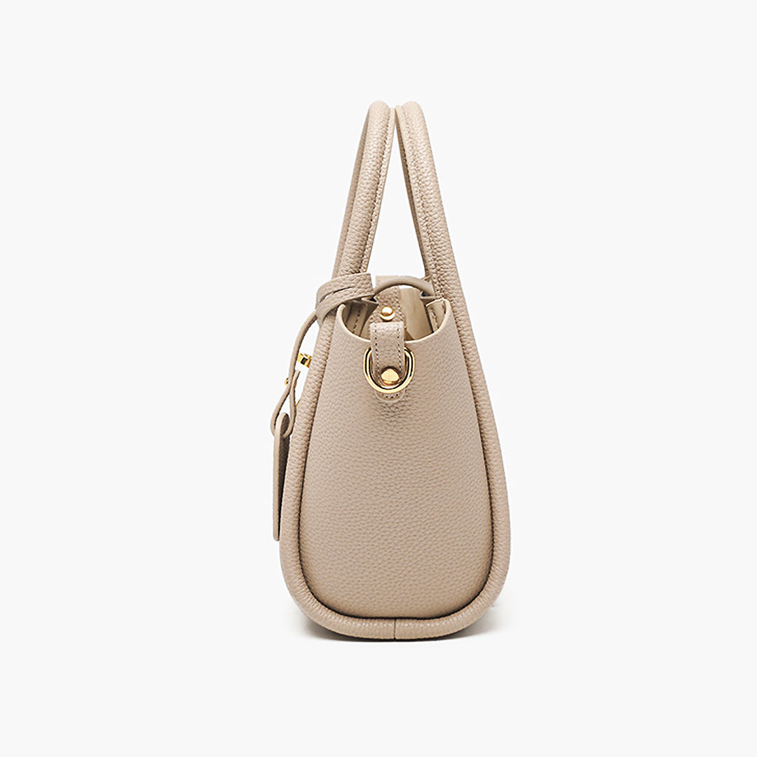 Beigefarbene Ledertasche, seitliche Ansicht, mit goldenen Details. Elegantes Design, ideal für Damenmode, Accessoires, Handtaschen.