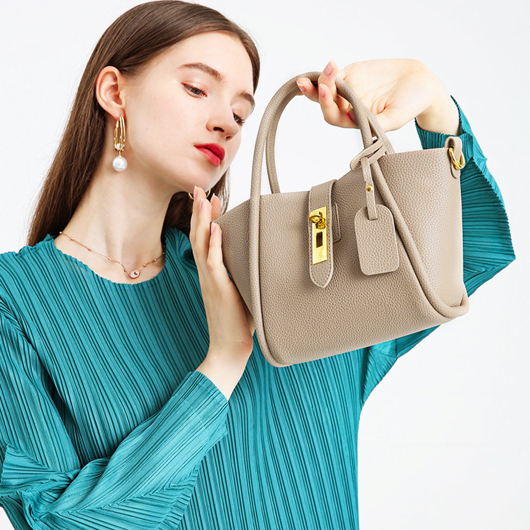 Damenhandtasche aus beigem Leder mit goldenen Details, elegant und modern. Perfekt für stilvolle Outfits. Hochwertige Modeaccessoires.