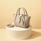 Elegante beige Handtasche aus Leder mit goldenen Details, abnehmbarem Schulterriemen und modernem Design. Perfekt für stilvolle Damenmode.