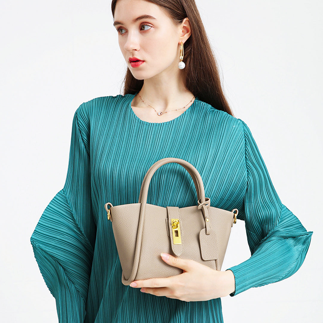 Damenhandtasche aus beigem Leder mit goldenen Details, elegant und modern. Perfekt für stilvolle Outfits. Hochwertige Modeaccessoires.
