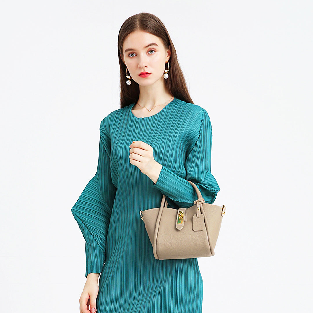Frau in elegantem, grünem Kleid hält stilvolle, beige Handtasche. Mode, Damenbekleidung, Accessoires, elegantes Design, trendige Handtaschen.
