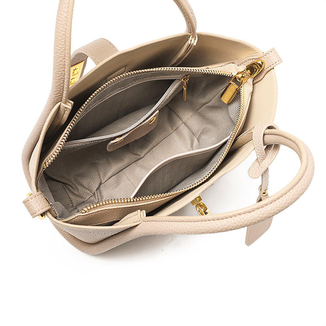 Beige Lederhandtasche mit goldenen Reißverschlüssen, mehreren Innenfächern und eleganter Struktur. Perfekt für stilvolle Damenmode.