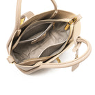 Beige Lederhandtasche mit goldenen Reißverschlüssen, mehreren Innenfächern und eleganter Struktur. Perfekt für stilvolle Damenmode.