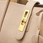 Luxuriöse beige Handtasche aus Leder mit goldener Schnalle. Elegantes Design, ideal für stilvolle Damenmode und hochwertige Accessoires.