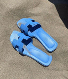 Blaue Sandalen auf Sand, ideal für den Strand. Bequeme Sommerschuhe, modisch und strapazierfähig. Perfekt für Urlaub und Freizeit.