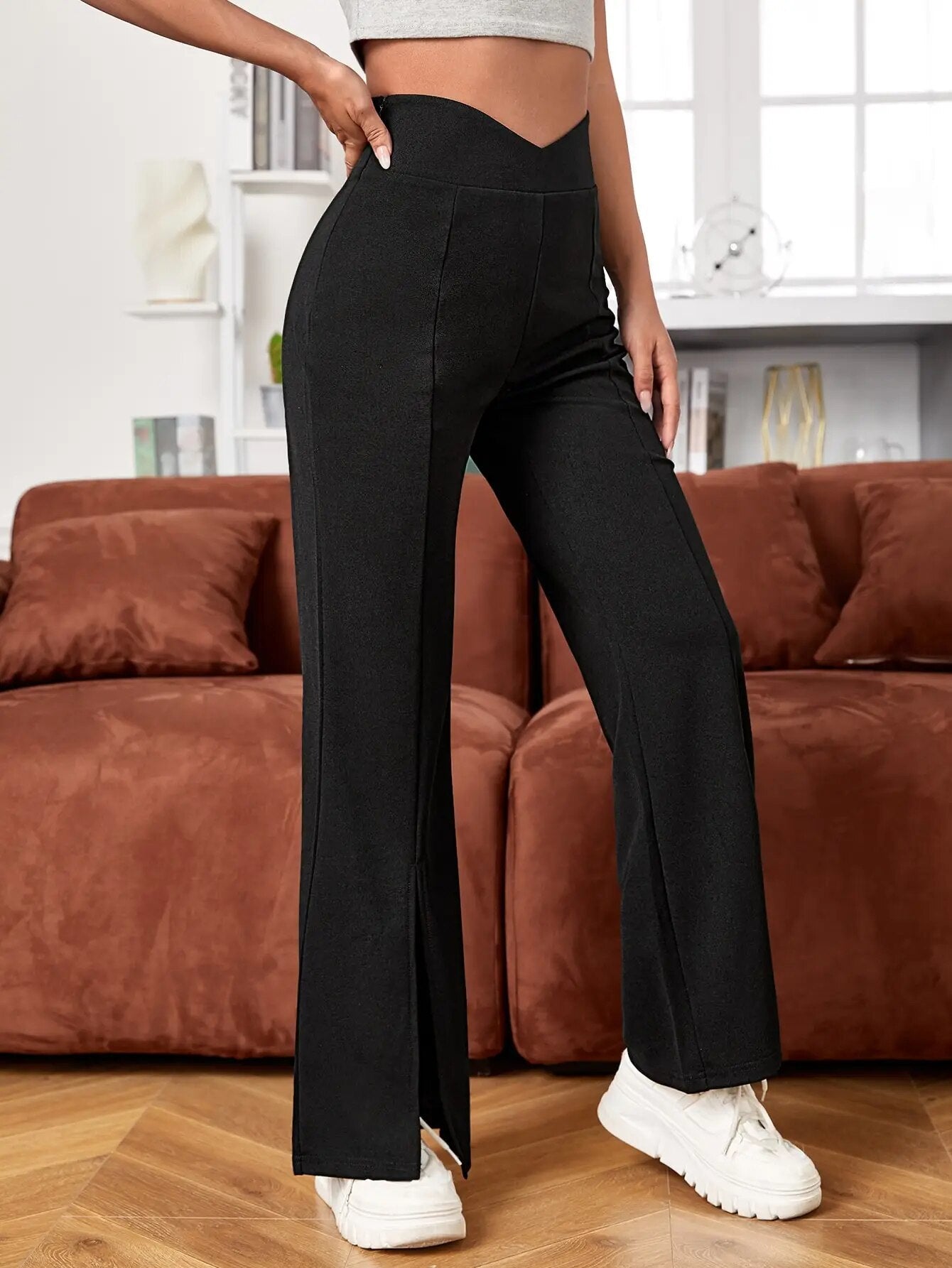 Schwarze Schlaghose für Damen, kombiniert mit weißen Sneakers. Perfekt für modische Freizeitlooks. Bequem und stilvoll für den Alltag.