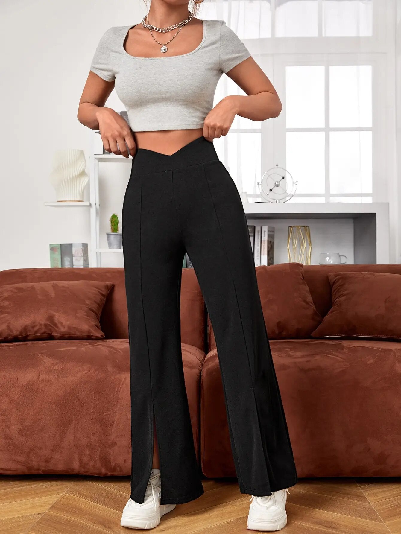 Damenmode: Schwarze Schlaghose mit hohem Bund und Schlitz, kombiniert mit grauem Crop-Top. Trendige Freizeitkleidung, bequem und stilvoll.