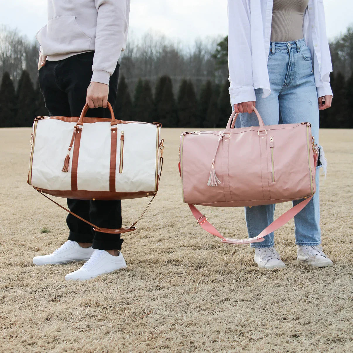 Zwei faltbare Reisetaschen, beige und rosa, mit Lederdetails, im Freien getragen.