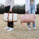 Zwei faltbare Reisetaschen, beige und rosa, mit Lederdetails, im Freien getragen.