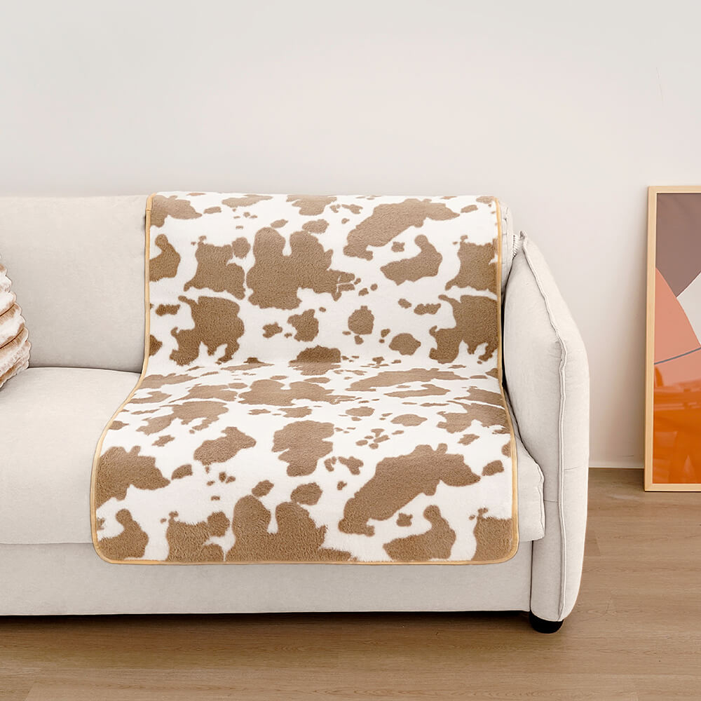 Kuhmuster Plüsch Haustiermatte auf weißem Sofa, braun-weiß, gemütlich, modisch, Wohnzimmer.