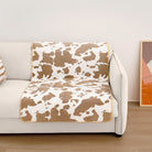 Kuhmuster Plüsch Haustiermatte auf weißem Sofa, braun-weiß, gemütlich, modisch, Wohnzimmer.