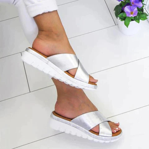 Silberne Sandalen mit breiten Riemen und weißer Sohle, ideal für Sommermode. Bequeme Damen-Slipper für stilvolle Freizeitlooks.