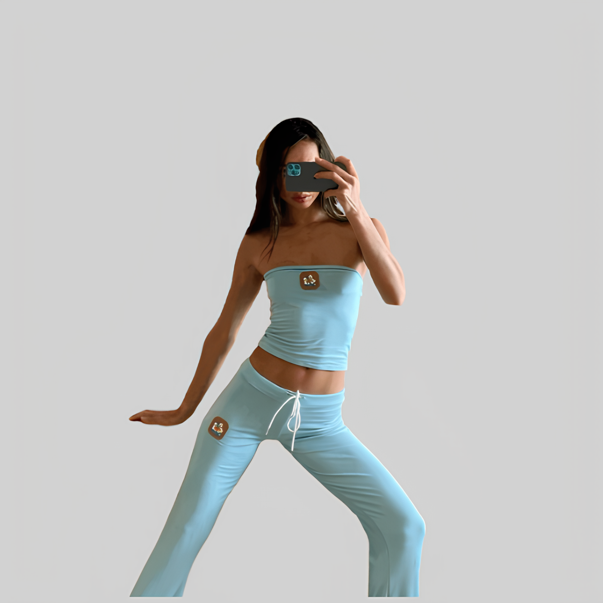 Frau in hellblauem Yoga-Set posiert vor grauem Hintergrund. Sportbekleidung, Fitnessmode, bequeme Kleidung, trendige Outfits, Selfie.