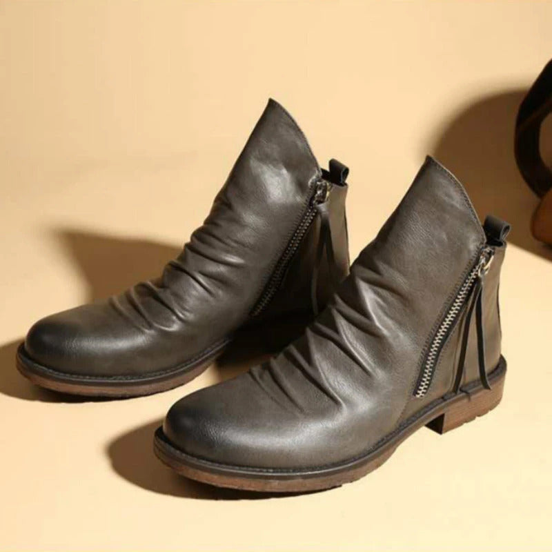 Graue Lederstiefeletten mit seitlichem Reißverschluss, rutschfester Sohle und modernem Design. Perfekt für Herbstmode und urbanen Stil.